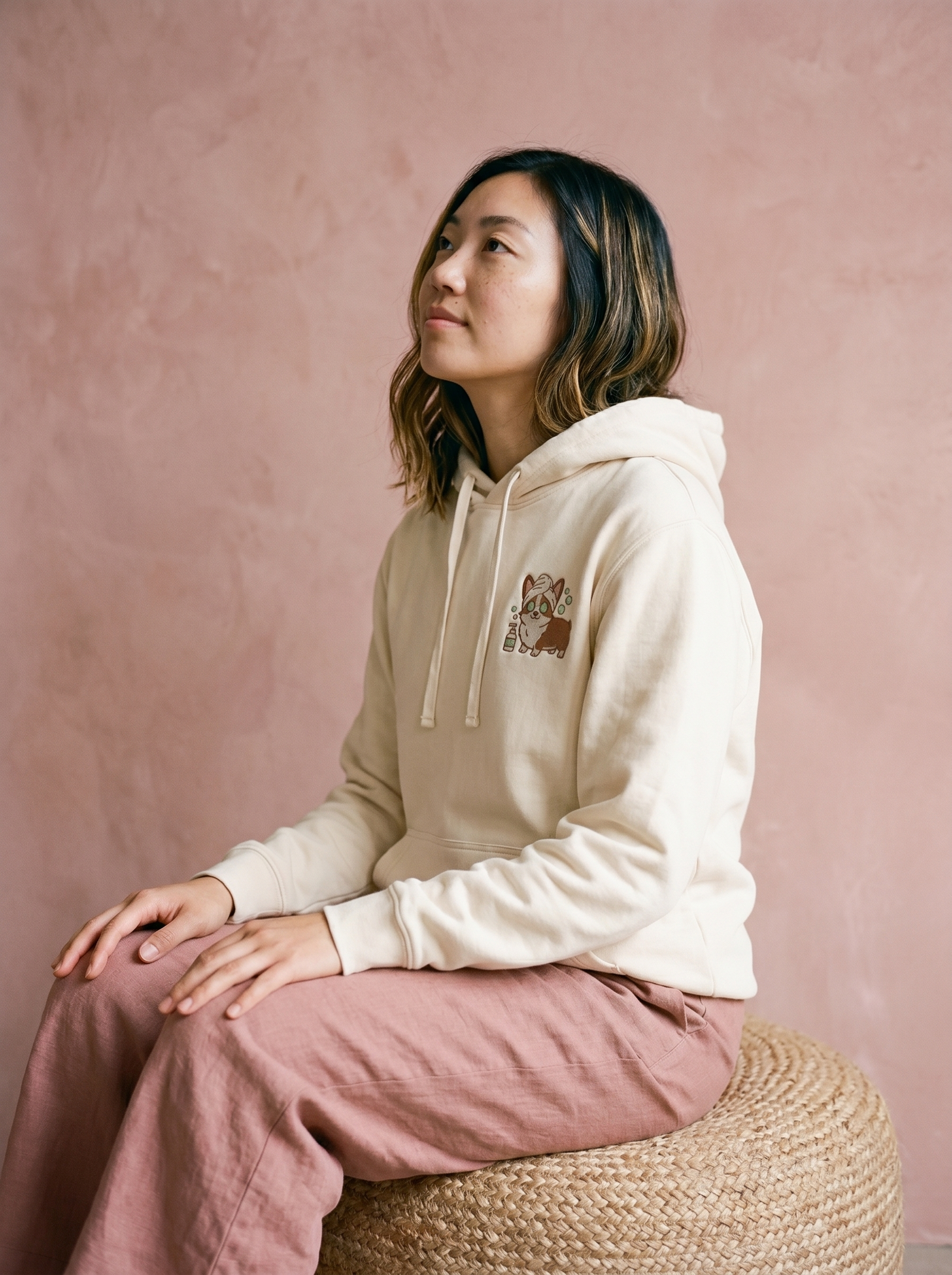 embroidered skincare corgi hoodie - model seated